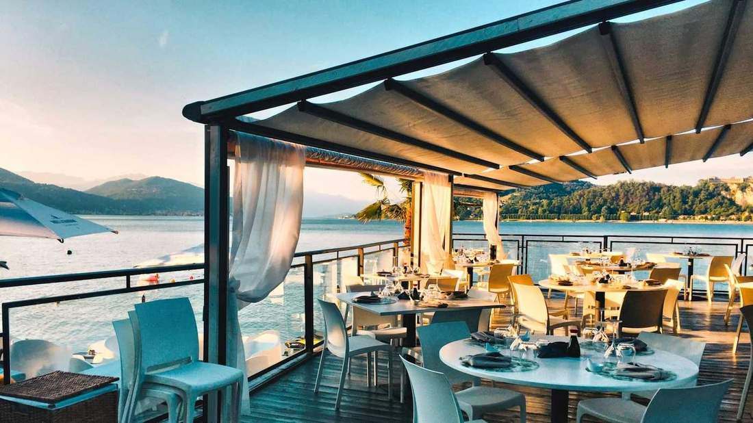 Upscale outdoor restaurant terrace overlooking water at sunset
